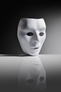 White plastic mask on reflective surface.