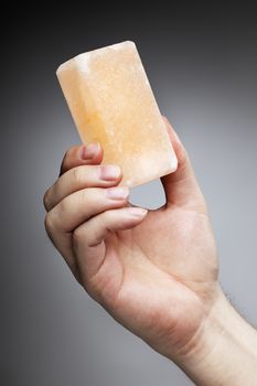 Man holding a himalayan salt soap bar, used for cleansing the skin or as a deodorant.
