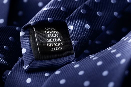 Label of a tie made of silk. Short depth of field, the sharpness is in the word Silk.