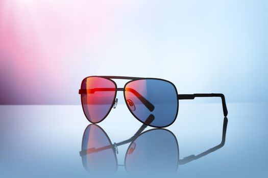 Sunglasses on reflective surface.