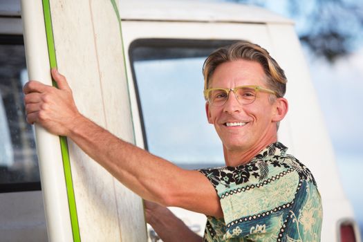 Smiling adult male with his surfboard in Hawaii