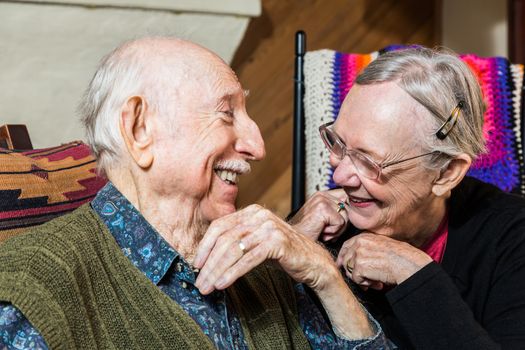 Happy Caucasian elderly couple sitting indoors smiling