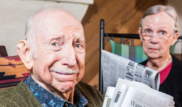 Elderly man and woman with the newspaper indoors