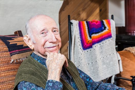 Older gentleman smiling and seated in his living-room