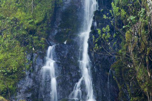 The falls in mountains flow from above and rustle