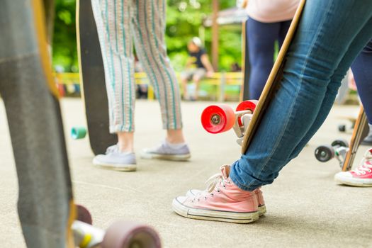 Teenagers practicing long board riding in skateboarding park. Active urban life. Urban subculture.