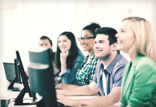 education concept - students with computers studying at school