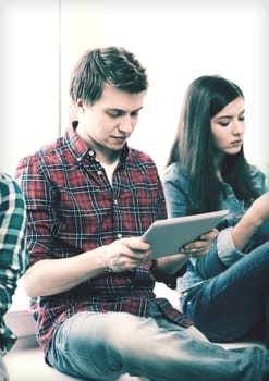 education and internet concept - student looking into tablet pc at school