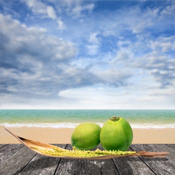 Nice coconut on deck at beach with sea and sky background