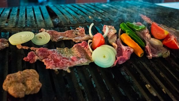 Meat and vegetables char grilled over flame