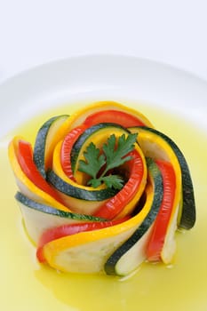 Appetizer twisted into a spiral of zucchini, tomato and sauce