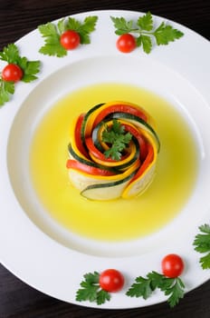 Appetizer twisted into a spiral of zucchini, tomato and sauce
