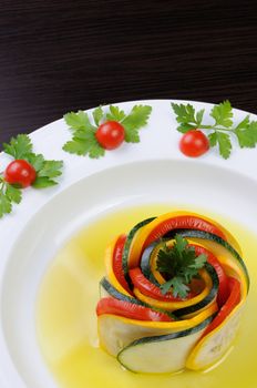 Appetizer twisted into a spiral of zucchini, tomato and sauce