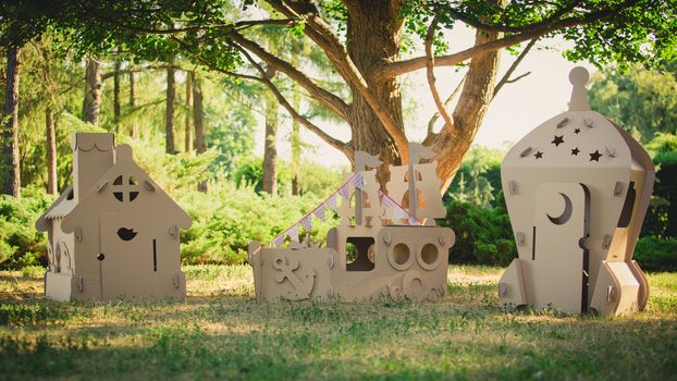Eco-friendly toys made of cardboard ship, a house and a spaceship. Summer day. Eco concept