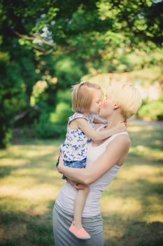 Mom playing with daughter in the park. Concept of a happy family