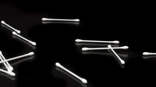 Cotton Swabs on Black Background Spread out.