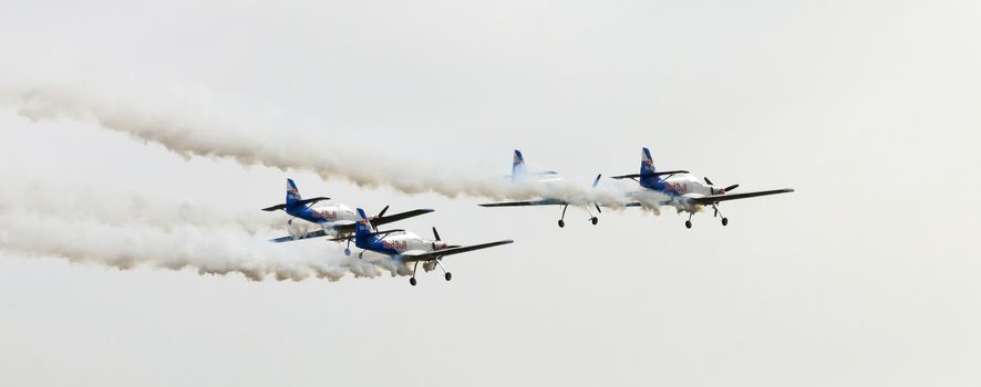 Plasy, Czech Republic - April 27, 2013: The Flying Bulls Aerobatics Team on the Airshow "The Day on Air". The team fly four modified Zlin Z-50 LX aircraft, painted in the colors of Red Bull energy drink for sponsorship reasons