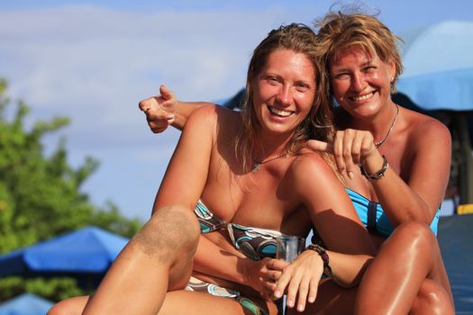 Two adult women smiling at the beach