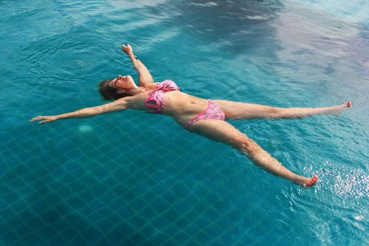 Adult woman enjoying summer in the pool