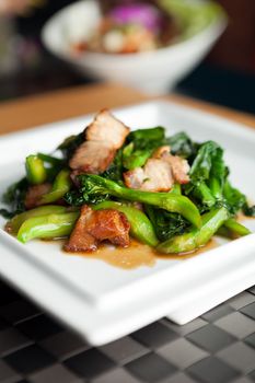 Thai style crispy pork dish with Chinese broccoli.  Shallow depth of field.