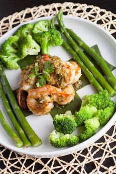 Shrimp scampi seafood dish with broccoli and asparagus.  Shallow depth of field.