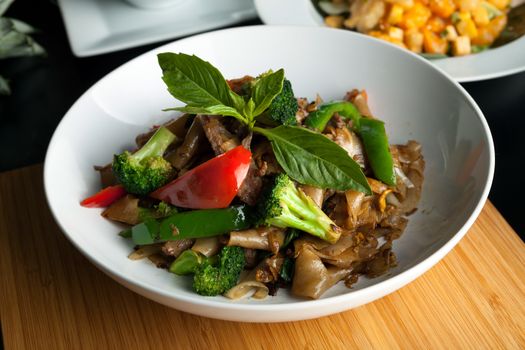 Pad kee mao drunken noodle thai dish with beef and mixed vegetables.