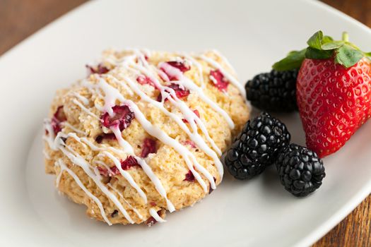 Orange Cranberry Scone with fresh fruit.  Shallow depth of field.