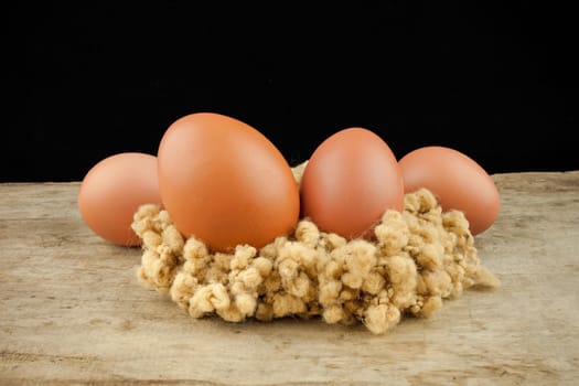 fresh brown eggs on wood background .