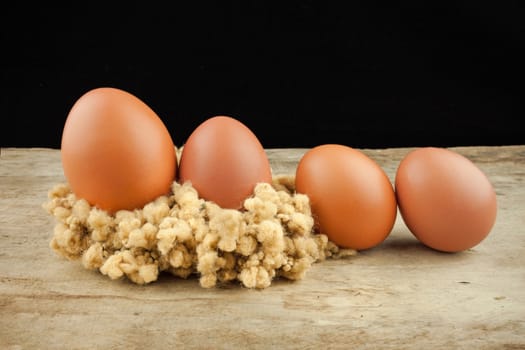 fresh brown eggs on wood background .