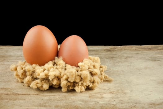 fresh brown eggs on wood background .