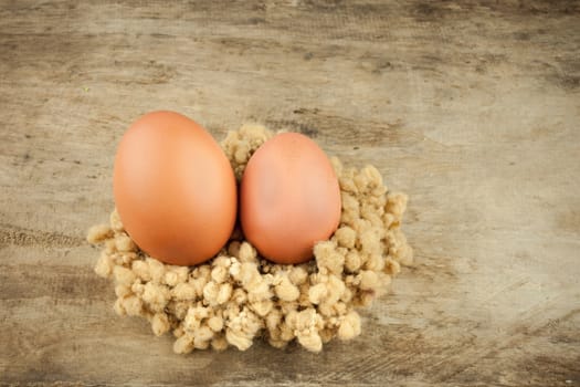 fresh brown eggs on wood background .