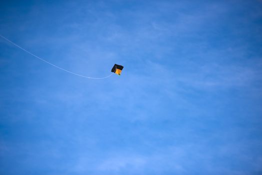 A bright colored kite soaring against the blue sky