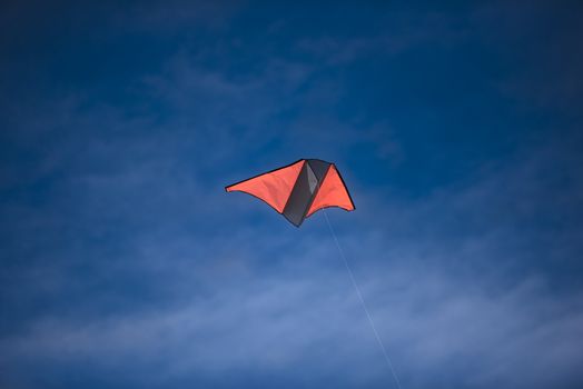 A bright colored kite soaring high in the blue sky