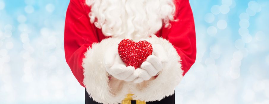 christmas, holidays, love, charity and people concept - close up of santa claus with heart shape decoration over blue lights background