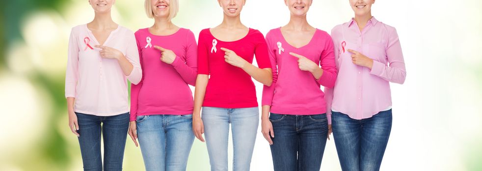 healthcare, people, gesture and medicine concept - close up of smiling women in shirts with pink breast cancer awareness ribbons showing ok sign over green background