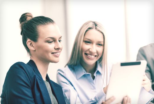 business, technology and office concept - smiling businesswomen with tablet pc computers having discussion in office