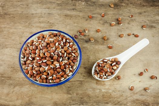 Portion of nature peas in bowls on wooden background.