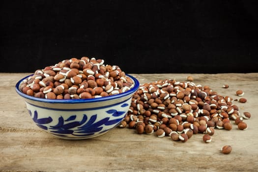 Portion of nature peas in bowls on wooden background.