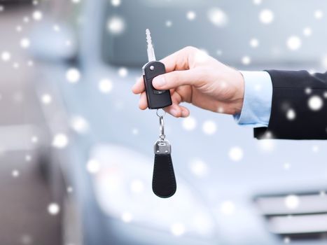 transportation, people, season and ownership concept - close up of man with car key outdoors