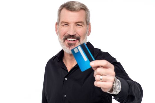 Senior man showing his credit card to camera