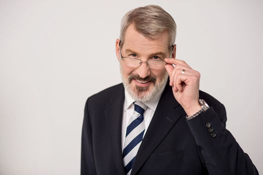 Senior businessman adjusting his glasses for clear view