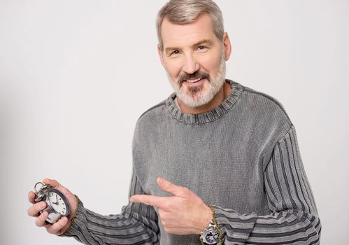 Mature man pointing at an antique time piece