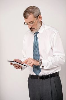 Senior entrepreneur browsing on his tablet pad