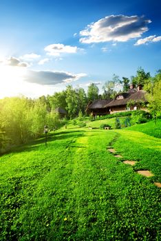 Wooden houses on green meadow in spring