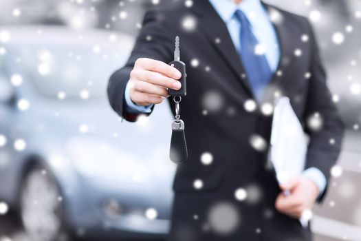 transportation, people, season and ownership concept - close up of man with car key outdoors