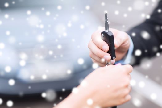 transportation, people, season and ownership concept - close up of man with car key outdoors