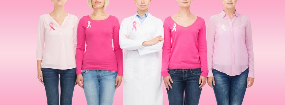 healthcare, people and medicine concept - close up of women in blank shirts with pink breast cancer awareness ribbons over pink background