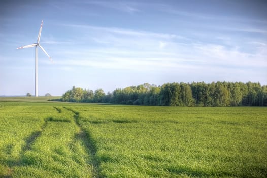 Windmill conceptual image. Windmills on the green field.