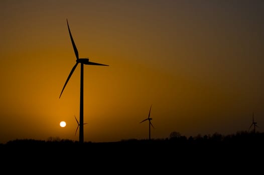 Windmill conceptual image. View on windmills during sunset.