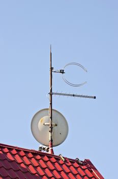satelite dish antenna on new tiled red  roof